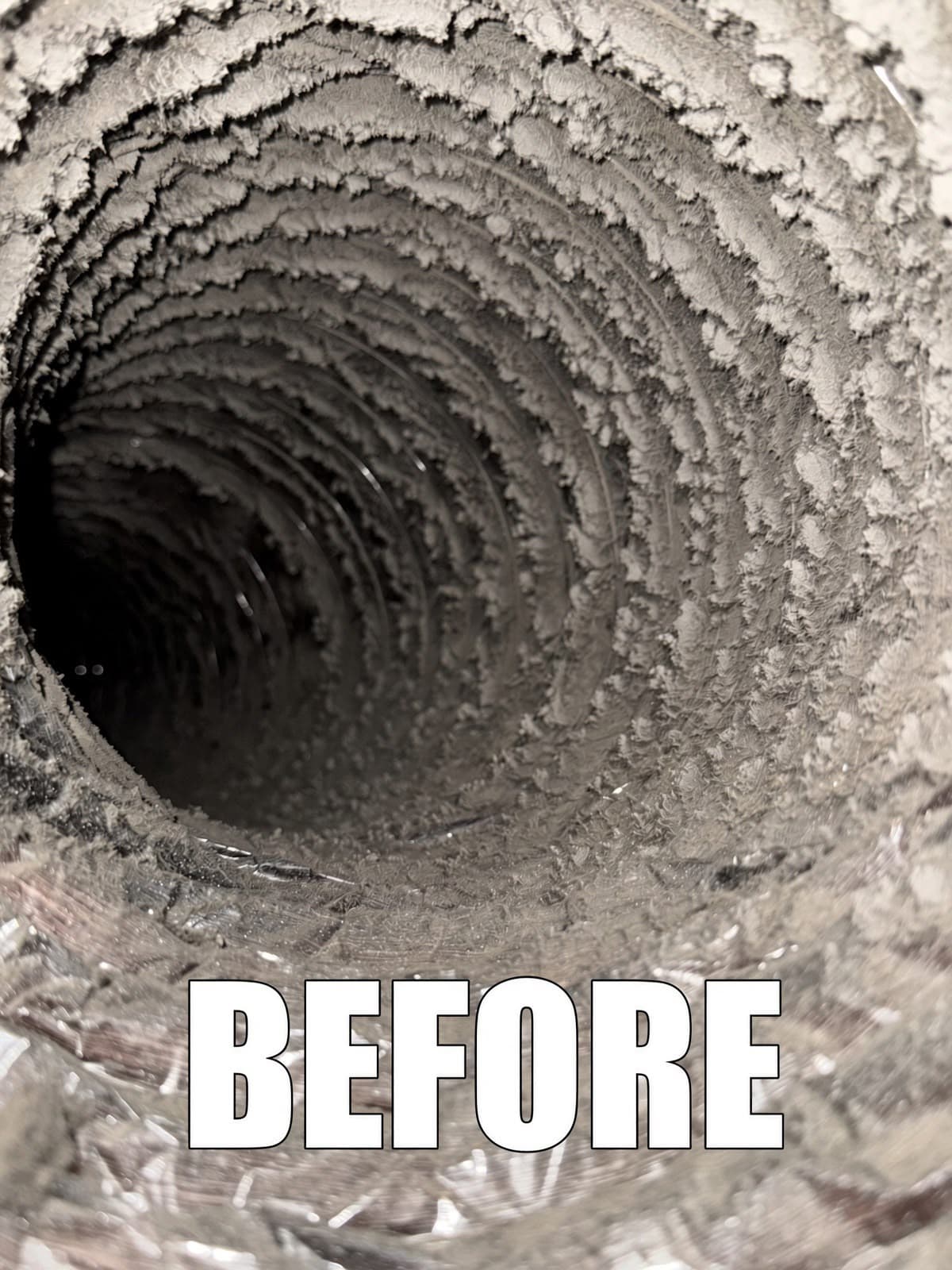 Interior of a circular air duct heavily clogged with thick lint and 'BEFORE' text overlay.